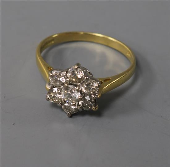 A modern 18ct gold and seven stone diamond cluster ring, size M.